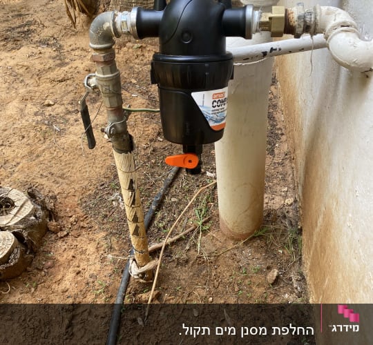 מסנן מים מותקן על צינור חיצוני ליד קיר